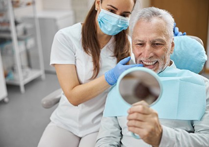 a patient checking his smile with a mirror