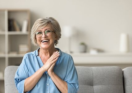 a woman smiling while sitting on a couch 