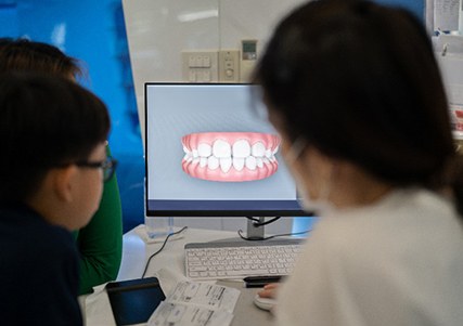 Cosmetic dentist and patient looking at rendering of patient's smile