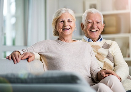 Happy senior couple sitting on sofa